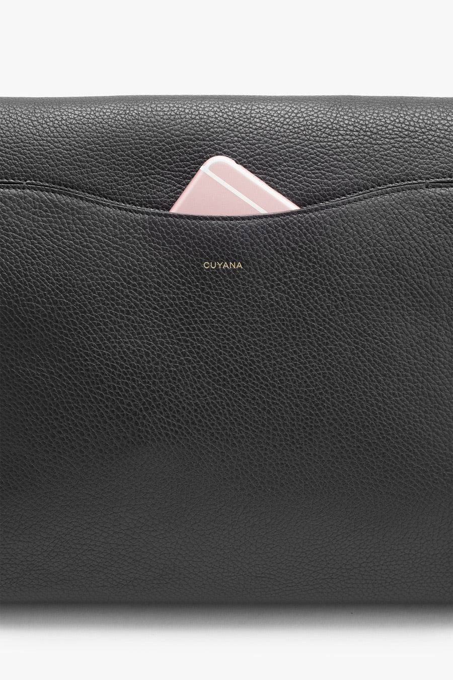 Close-up of a textured bag with a brand name and a phone peeking out.