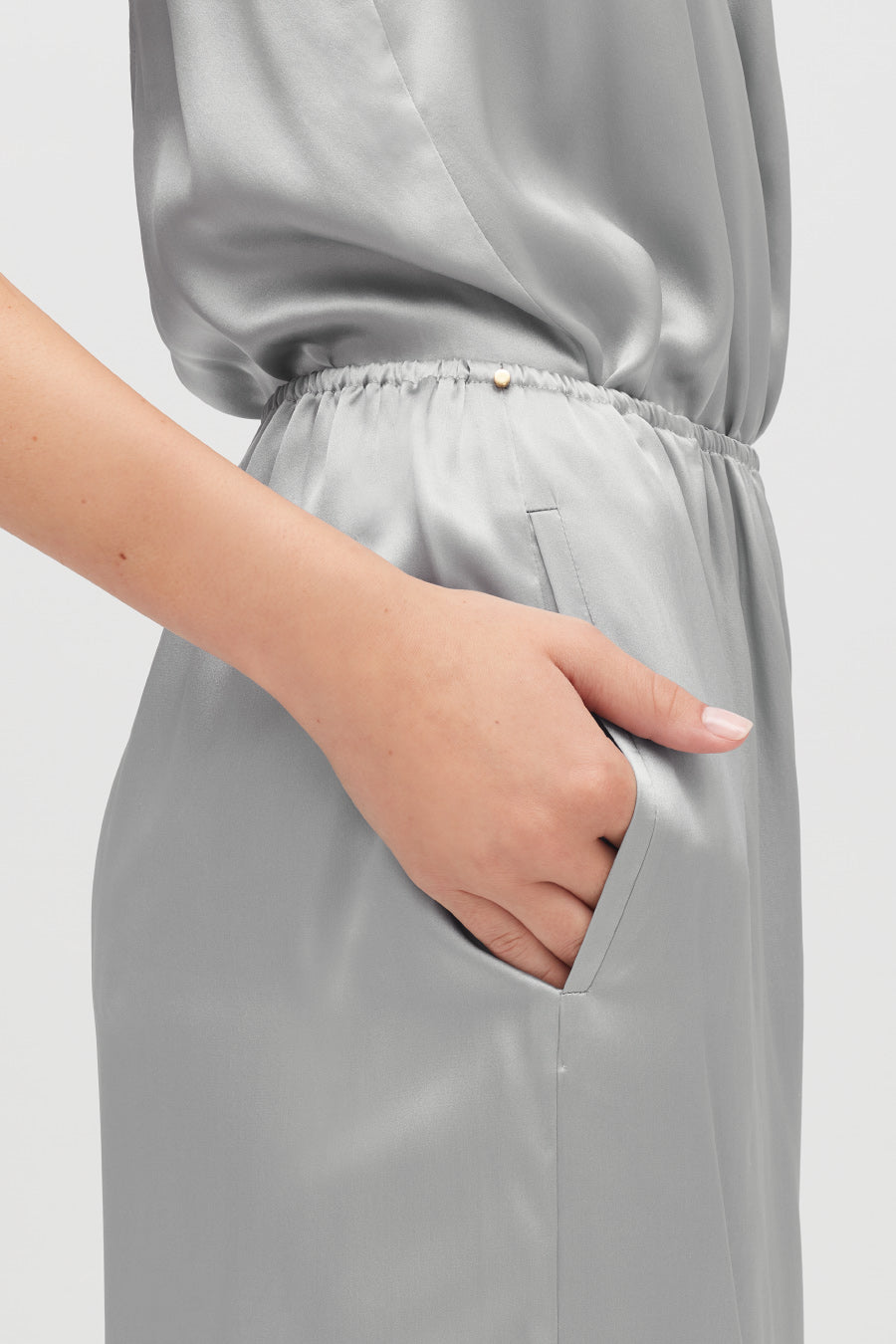 Person with hand in pocket of a draped outfit.