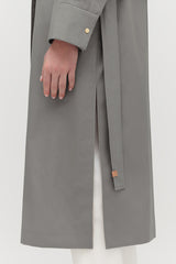 Person wearing a coat with a belt detail visible.