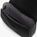 Open black handbag with visible compartments and a logo imprint inside.