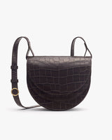 Crossbody bag with croc-embossed leather and round flap.