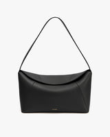 A handbag with a curved shape and single strap.