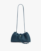 Drawstring shoulder bag with a long strap on a plain background