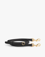 Leather strap with metal clasps and a ring detail.