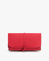 Rectangular clutch with a tied strap closure.