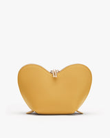 Heart-shaped handbag with a clasp closure and two small feet at the base.