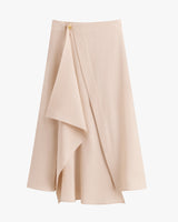 Flowy skirt with asymmetric layered design and small button detail.