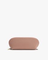 A rounded zipper pouch laying flat.