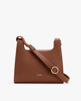 Rectangular handbag with adjustable strap and round metal clasp.