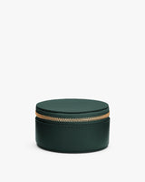 Round zippered leather case against white background