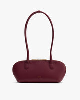 Oval-shaped handbag with two long handles and a zipper closure.