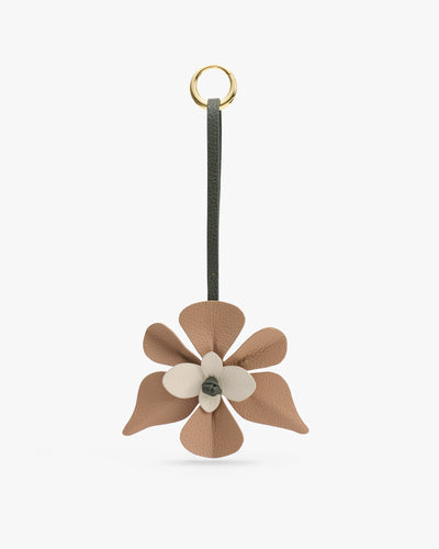 Flower-shaped leather keychain with a loop.