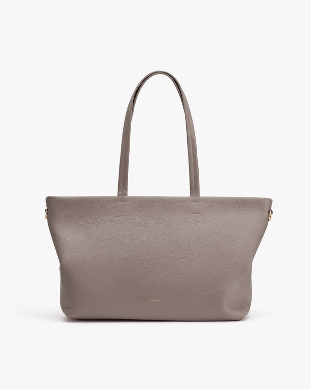 Tote bag with long handles on plain background.