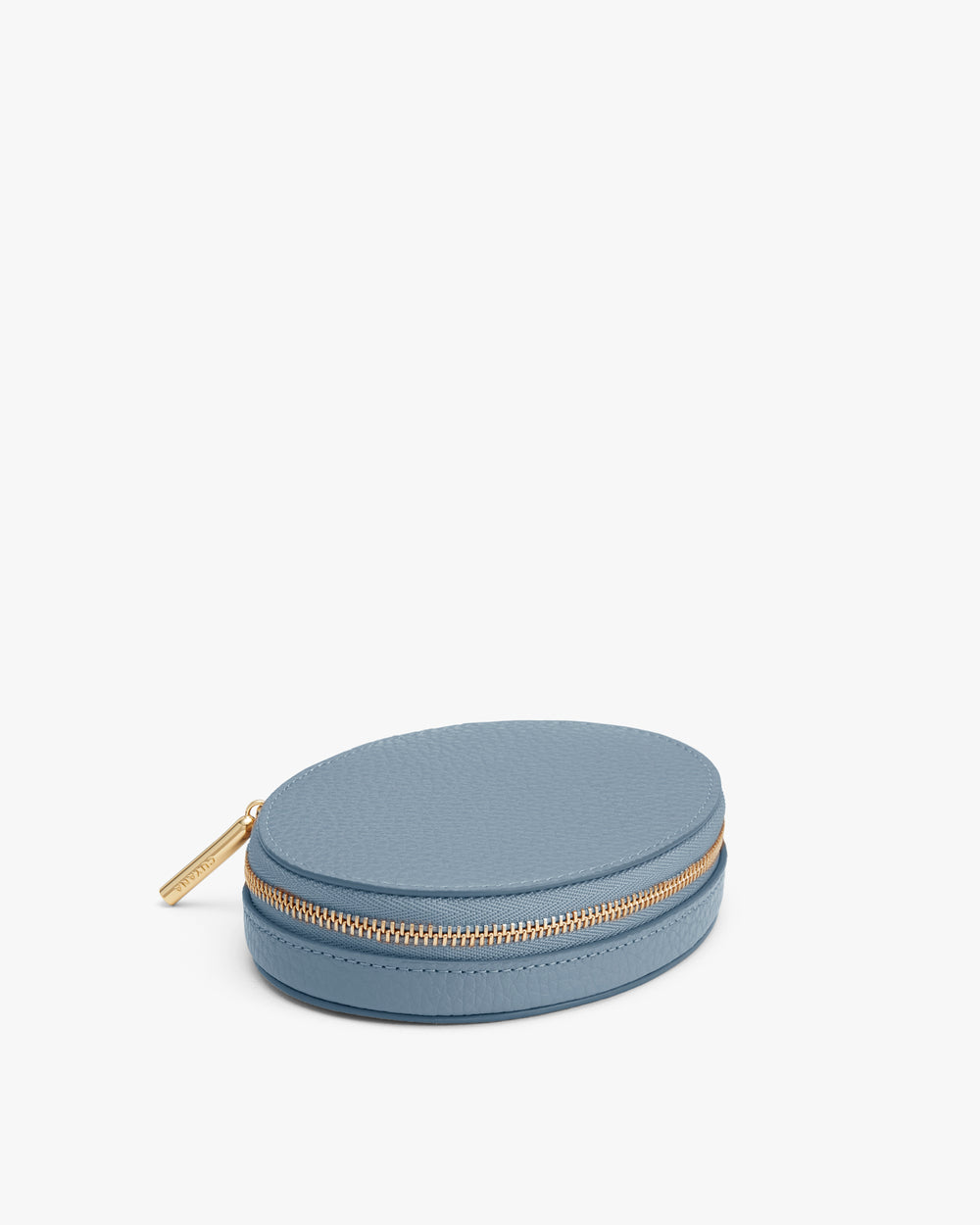 Small round zippered case with textured surface and a zip closure.