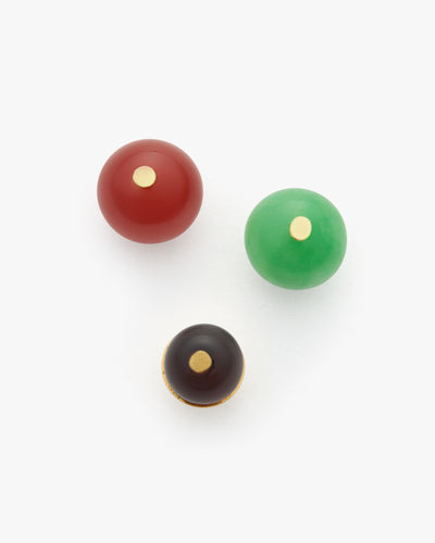 Three spherical charms with small circular details are arranged.