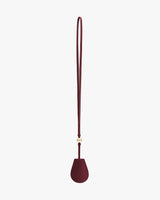 Teardrop-shaped bag charm with long strap.