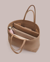 Open tote bag with a water bottle, laptop, and pouches inside