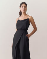 Woman wearing sleeveless top and wide-leg pants, with hand in pocket