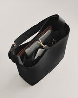 Open tote bag with various items inside, including a phone, tablet, and wallet