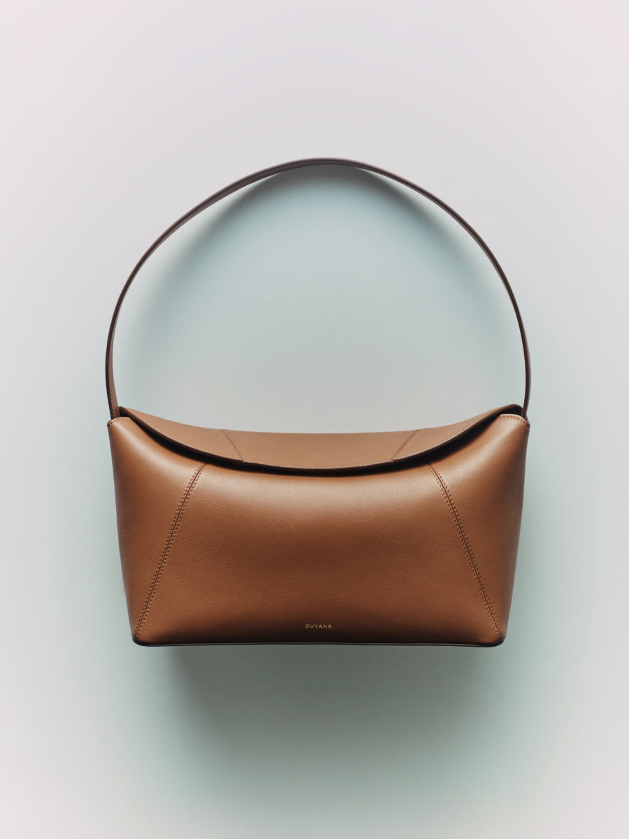 Handbag with a curved handle displayed against a plain background.