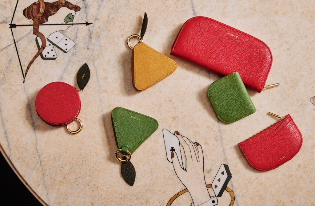 Wallets and small, different shaped pouches on a marble table.