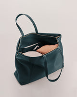 Open handbag with clothing and items inside
