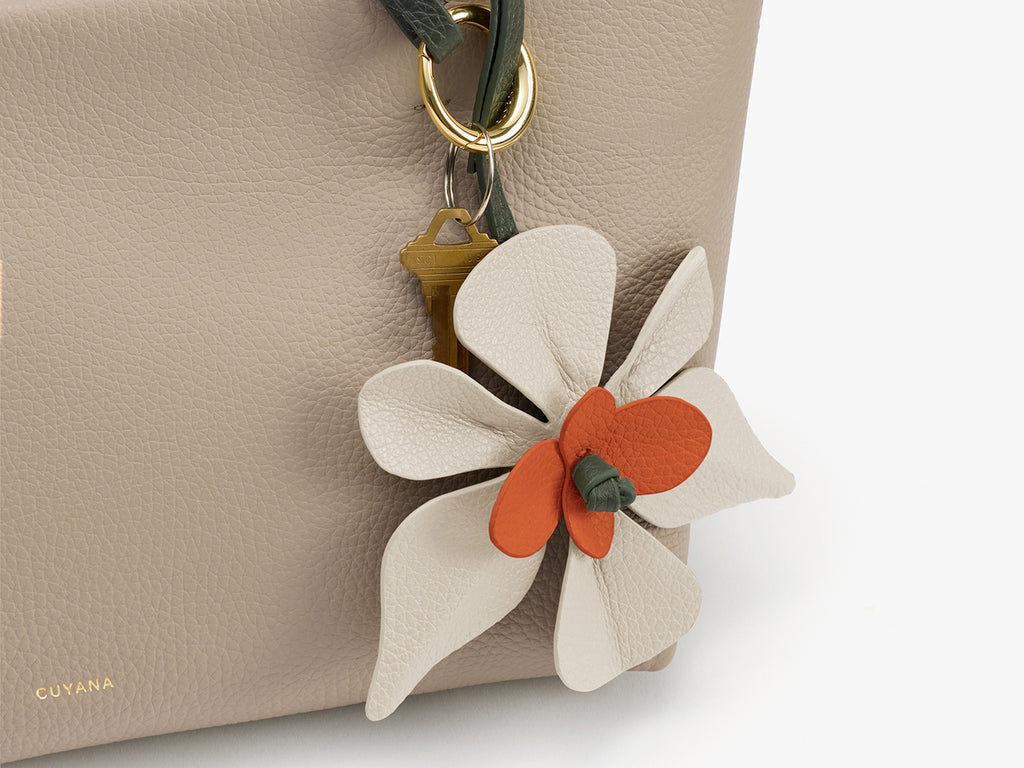 Close-up of flower charm attached to bag handle.