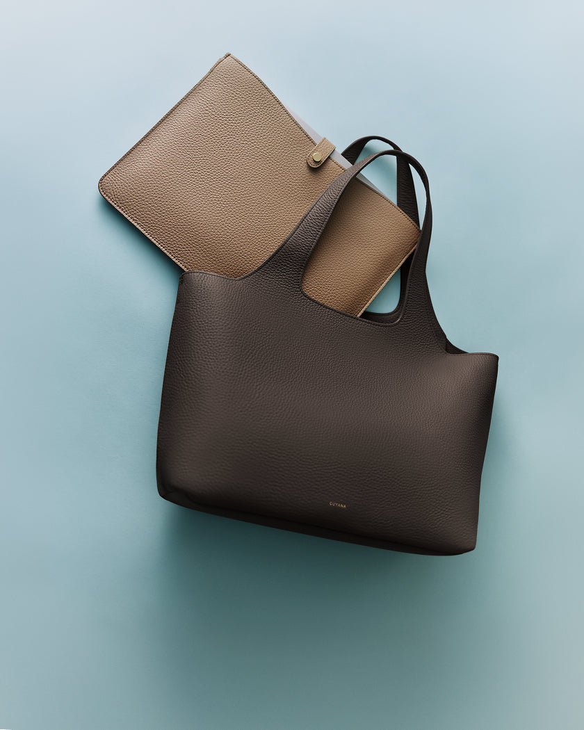 Two handbags, one smaller overlapping a larger tote.
