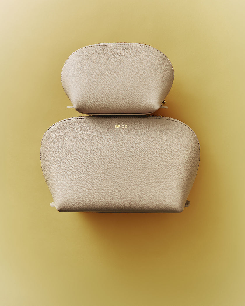 Two textured pouches stacked on a plain background.