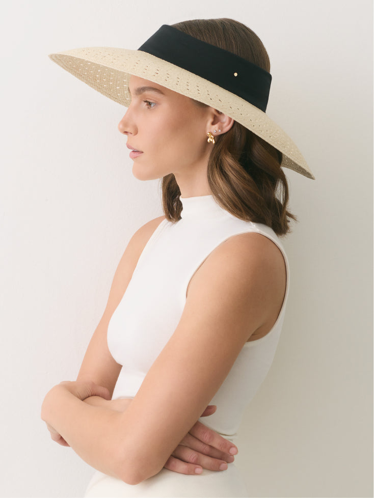 Person wearing a wide-brimmed hat and sleeveless top shown in profile.