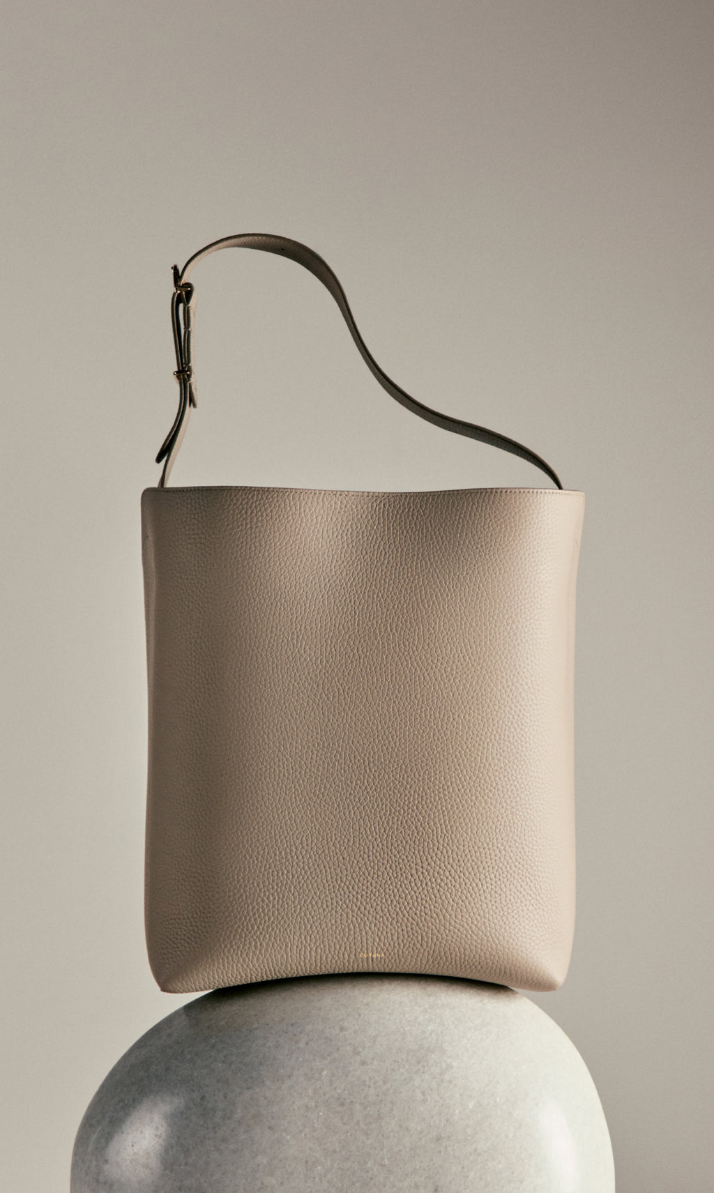 Minimalist handbag on spherical pedestal