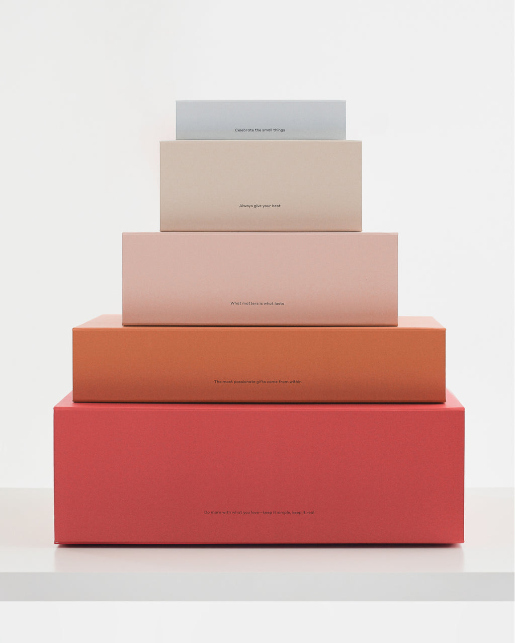 Stack of five rectangular boxes in varying sizes on a white surface