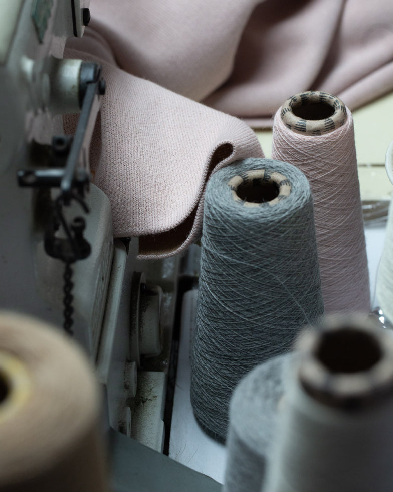 Sewing machine with fabric rolls and yarn spools