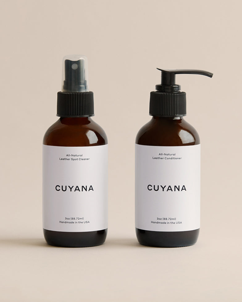 Two bottles labeled Cuyana, one with a spray nozzle and one with a pump.