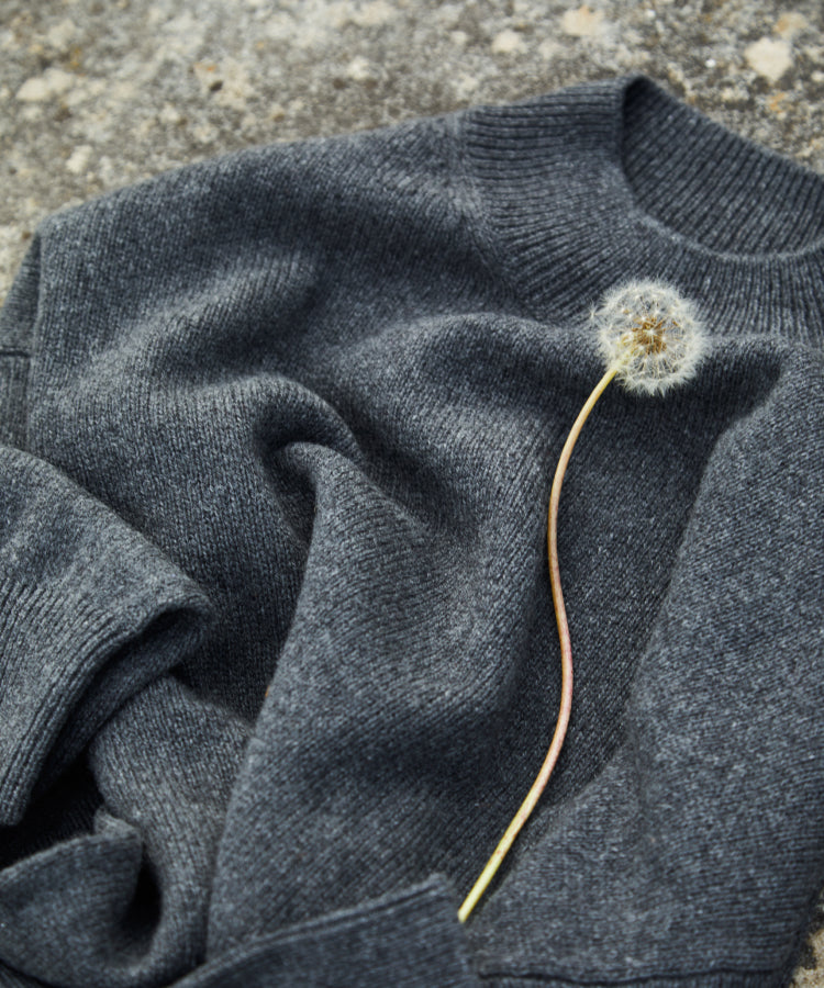 A dandelion on a folded sweater.