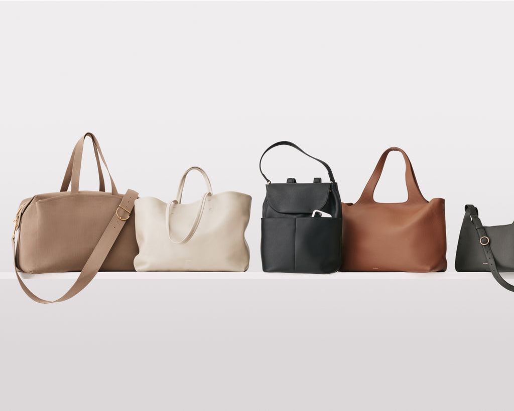 Five different styles of handbags arranged in a row on a plain background.