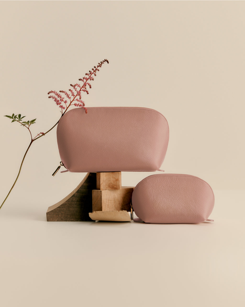 Modern chair and ottoman with various blocks under leg, next to a potted plant