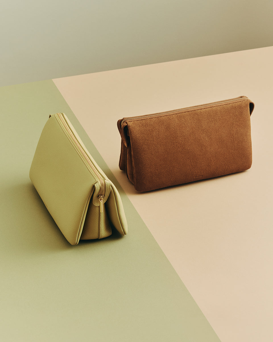 Two rectangular clutches on a two-tone surface.