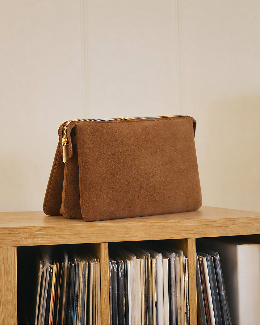 Rectangular clutch on a shelf with records below.