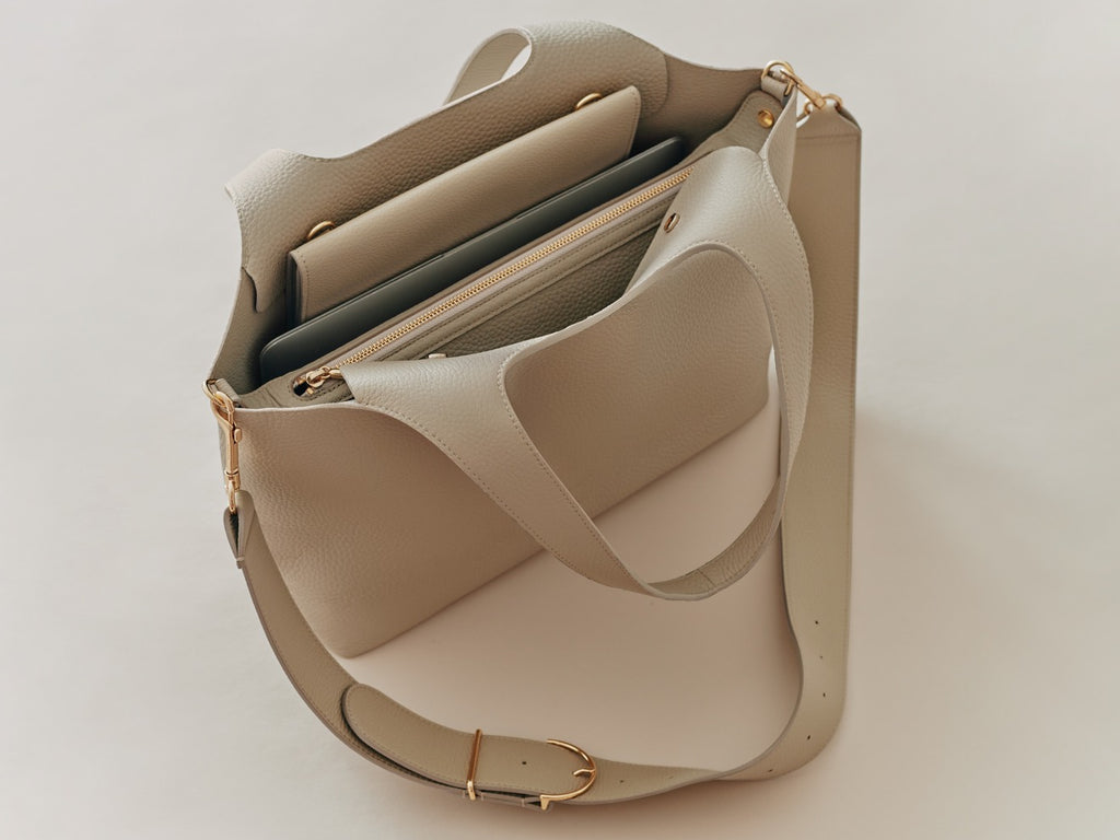 Open handbag with multiple compartments and a long strap.