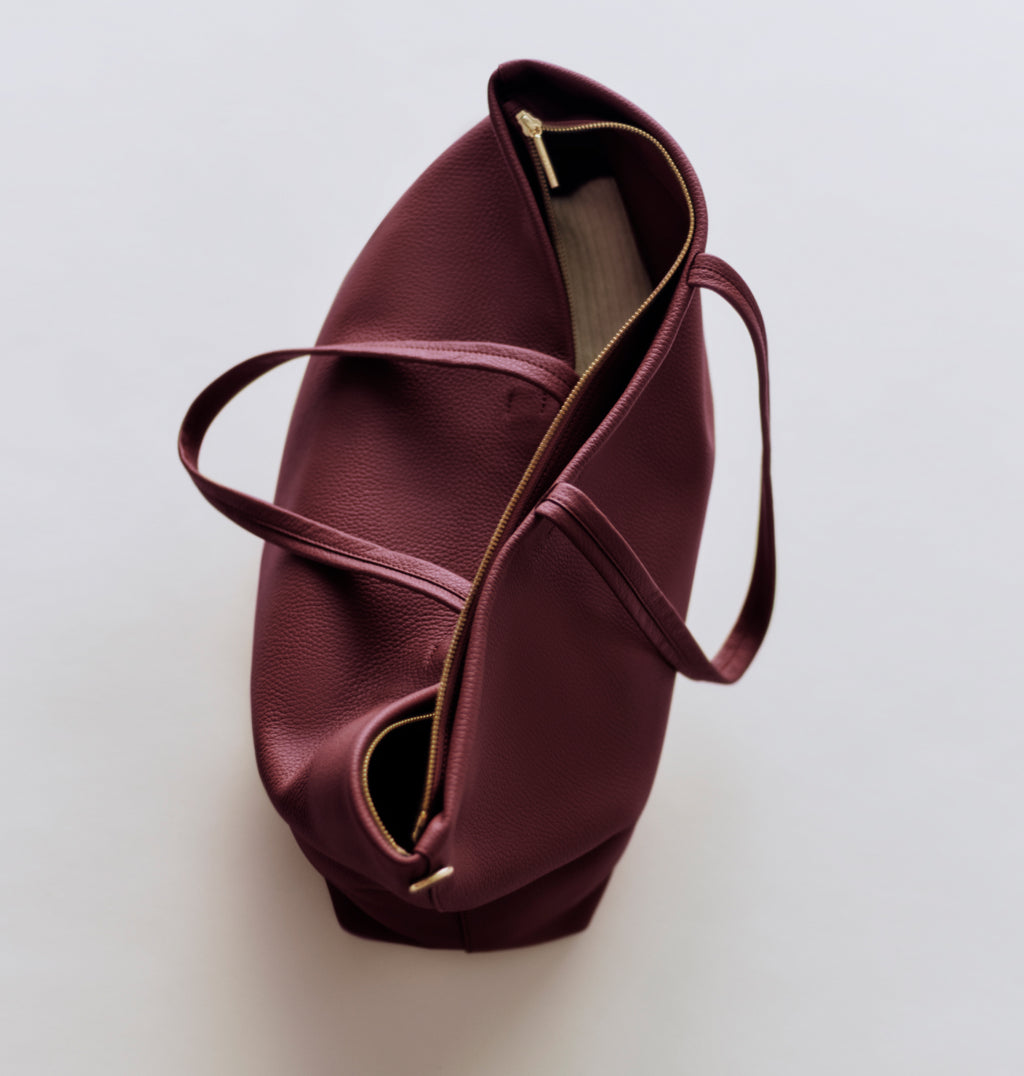 A tote bag with handles and zippered opening.