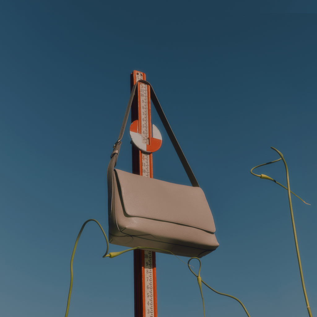 Bag hanging from a road sign, clear sky in the background