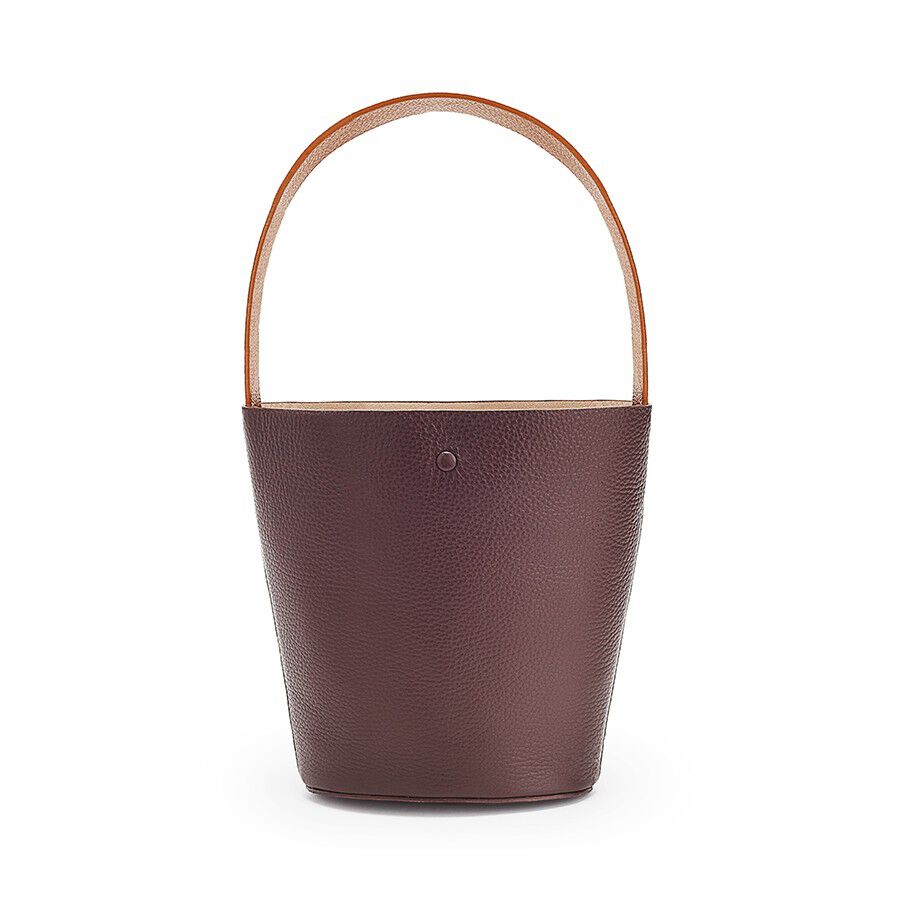 Handbag with a single handle and a textured exterior.