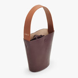 Leather tote bag with top handle and visible contents inside.