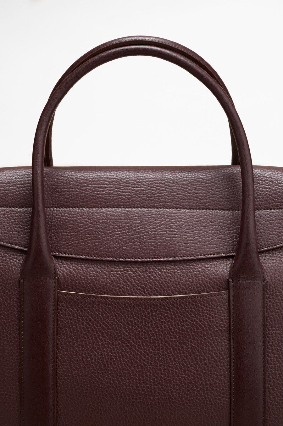 Close-up of the top of a handbag with handles.
