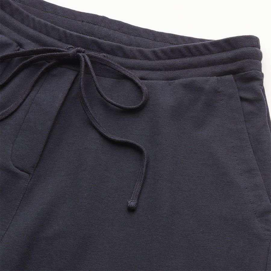 Close-up of sweatpants with elastic waist and drawstring.