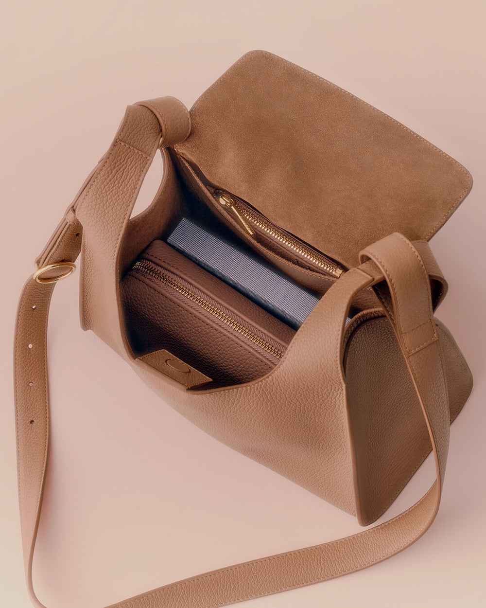 Open handbag with books and a wallet inside.