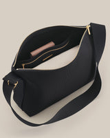 Handbag with zipper open revealing interior with items inside.