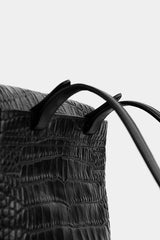 Close-up of a handbag with a textured design and handles