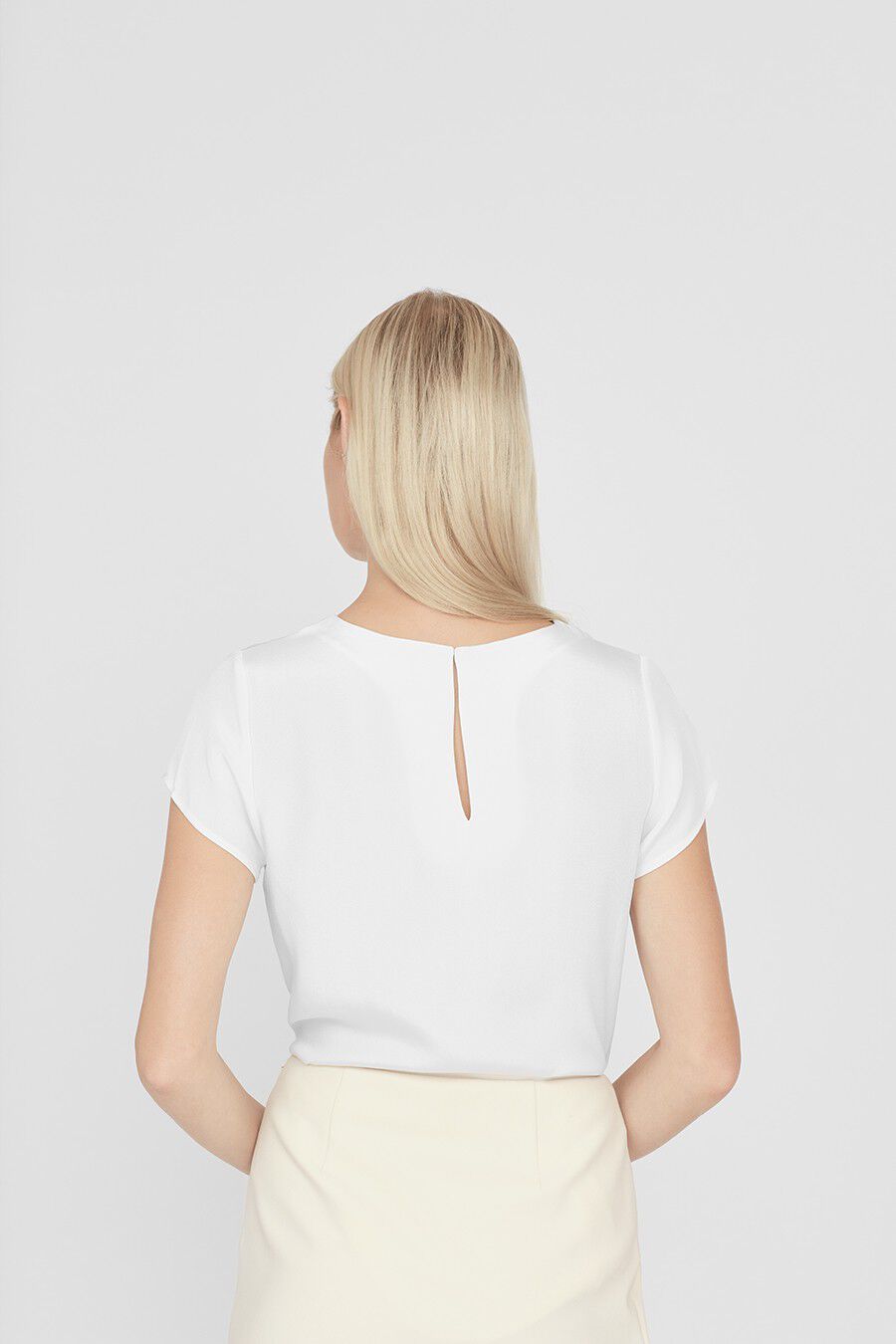 Woman seen from behind, wearing a top with a keyhole at the neck.